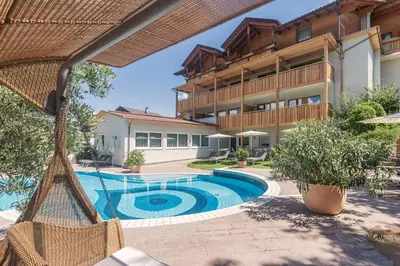 a swimming pool in front of a building at Wanderhotel Teiserhof in Funes