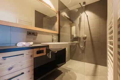 a bathroom with a sink and a shower at Wanderhotel Teiserhof in Funes