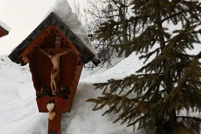 a wooden birdhouse in the snow next to a tree at Alpin Apartments Colfosco in Colfosco