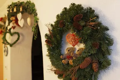 a christmas wreath with a teddy bear on a wall at Alpin Apartments Colfosco in Colfosco