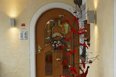 a door with a christmas tree with red flowers at Alpin Apartments Colfosco in Colfosco