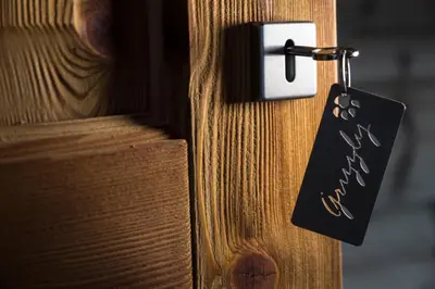 a tag hanging from a door knob on a wooden door at Grizzly Haus & Frosch Restaurant - Teritoria in Varena