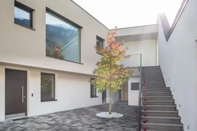 a tree in front of a building with a staircase at Hof im Kalch Tramin in Termeno