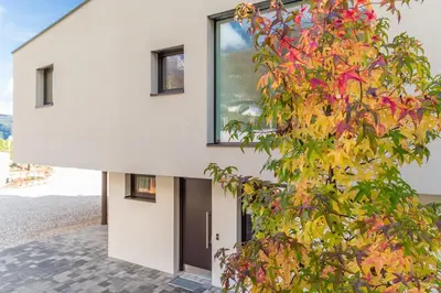 a building with a tree with colorful leaves at Hof im Kalch Tramin in Termeno