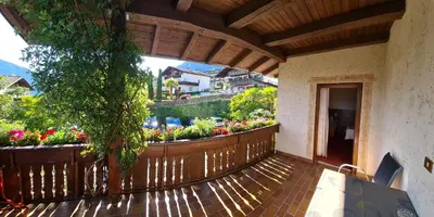 a balcony with a wooden fence and flowers at Garni Pöhl in Tirolo