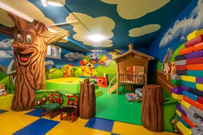 a childs play room with a tree mural at Hotel Al Lago in Soraga
