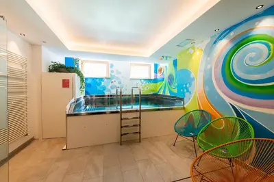 a bathroom with a tub with a painting on the wall at Hotel Al Lago in Soraga