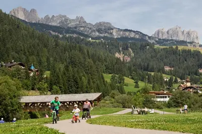 a group of people riding bikes down a road at Hotel Al Lago in Soraga