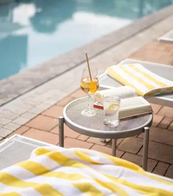 a table with a book and a glass of wine at Hotel Eichenhof in Tirolo