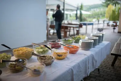 a table with bowls of food and plates on it at Hotel Eichenhof in Tirolo