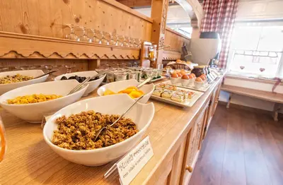 a buffet with bowls of food on a counter at Garnì Aurora Bed and Breakfast in Soraga
