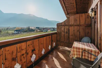 a balcony with a table and chairs and a view at Weihergut in Cermes