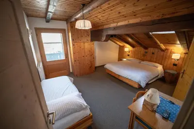 a bedroom with two beds and a couch in it at B&B Bucaneve in Vigo di Fassa