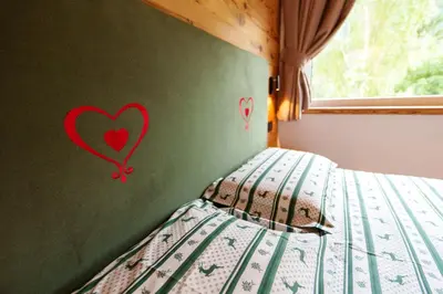 a bedroom with a bed with hearts painted on the wall at B&B Bucaneve in Vigo di Fassa