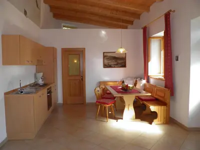 a kitchen with a table and chairs in a room at Appartementhaus Linter in Tirolo
