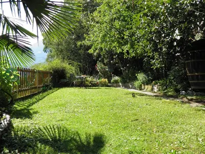 a yard with a fence and a table and chairs at Appartementhaus Linter in Tirolo