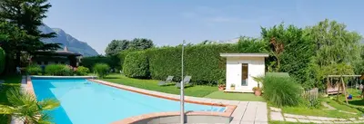a swimming pool in a yard with a house at Hotel Villnerhof in Egna