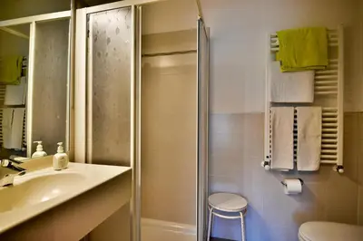 a bathroom with a shower and a sink and a toilet at Hotel Villnerhof in Egna