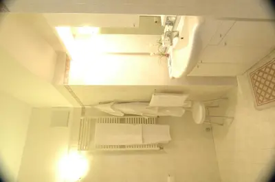 a small bathroom with a toilet and a sink at Hotel Savoia in Canazei