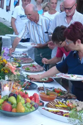 a group of people standing around a table full of food at Dependance Villnerhof in Egna