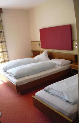 two beds in a hotel room with red cabinets at Dependance Villnerhof in Egna