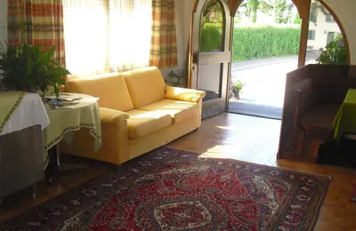 a living room with a yellow couch and a table at Dependance Villnerhof in Egna