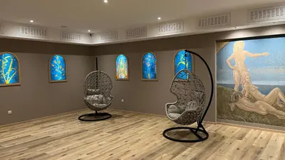 two chairs in a room with a painting and stained glass at B&B Garni Hotel Saxl in Campo di Trens