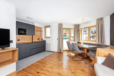 a kitchen and living room with a table and chairs at Residence Catarina Lanz in San Vigilio Di Marebbe