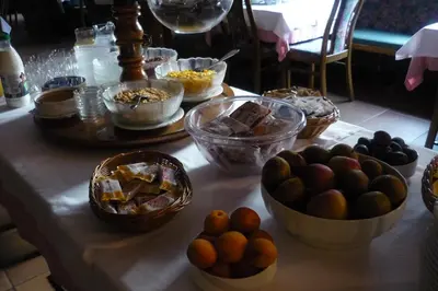 a table topped with bowls of food and baskets of fruit at Gasthof Obermair in Chienes