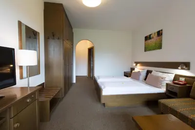 a hotel room with a bed and a couch at Pension Sankt Urban in Merano