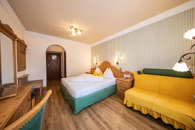 a hotel room with two beds and a television at PALMENGARTEN Hotel Gstör in Lagundo