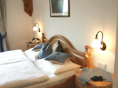 a bedroom with a bed with blue pillows on it at PALMENGARTEN Hotel Gstör in Lagundo