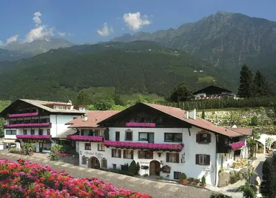 a house with flowers on the side of it at PALMENGARTEN Hotel Gstör in Lagundo