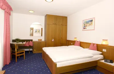 a hotel room with a bed and a desk at PALMENGARTEN Hotel Gstör in Lagundo