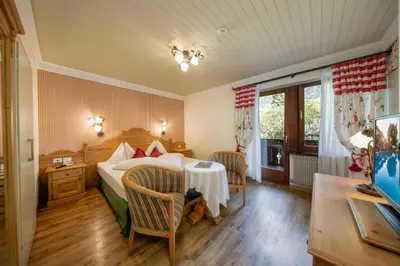 a bedroom with a bed and a table and chairs at PALMENGARTEN Hotel Gstör in Lagundo
