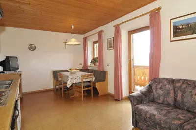 a living room with a table and a couch at Fiziderhof in Castelrotto