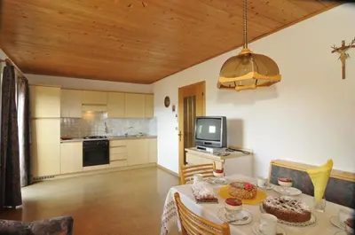 a kitchen and dining room with a table and a television at Fiziderhof in Castelrotto