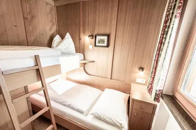 a small room with a bunk bed and a ladder at Aparthotel Kastel Seiser Alm in Castelrotto