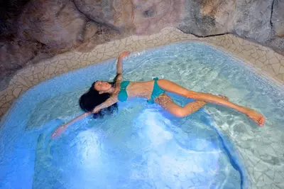 a woman floating in a pool in a water slide at Aparthotel Kastel Seiser Alm in Castelrotto