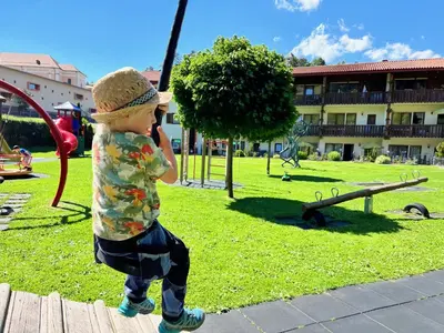 a young boy is playing on a playground at Aparthotel Kastel Seiser Alm in Castelrotto