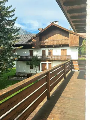 a house with a wooden fence in front of it at luminoso ed accogliente, centralissimo appartamento indipendente in Cortina dʼAmpezzo
