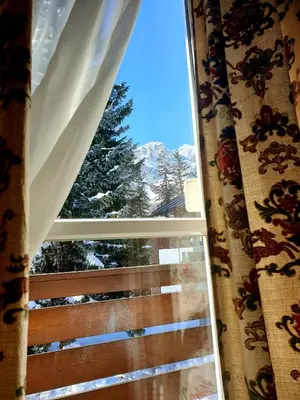 a window with a view of a snow covered mountain at luminoso ed accogliente, centralissimo appartamento indipendente in Cortina dʼAmpezzo