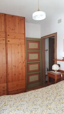 a bedroom with wooden closet doors and a bed at luminoso ed accogliente, centralissimo appartamento indipendente in Cortina dʼAmpezzo