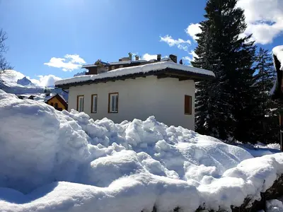a pile of snow in front of a house at luminoso ed accogliente, centralissimo appartamento indipendente in Cortina dʼAmpezzo