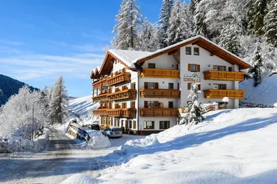 a large building in the snow with snow covered trees at Aktiv Hotel Schönwald in Nova Levante
