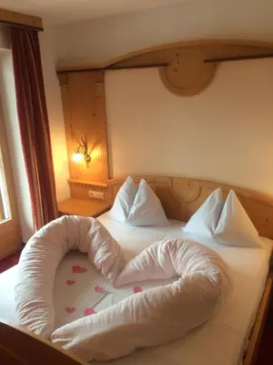 a bed with a heart shaped pillow on it at Aktiv Hotel Schönwald in Nova Levante