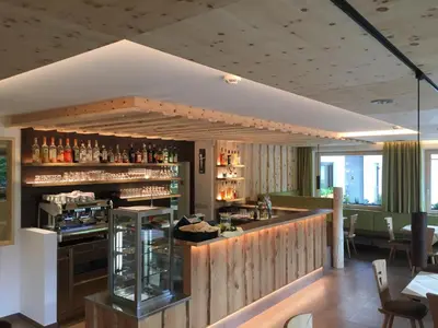 a bar in a restaurant with a wooden wall at Aktiv Hotel Schönwald in Nova Levante
