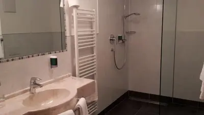 a bathroom with a sink and a shower at Aktiv Hotel Schönwald in Nova Levante