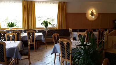a dining room with tables and chairs and windows at Aktiv Hotel Schönwald in Nova Levante