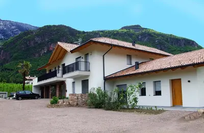 a large white building with a mountain in the background at Gisshübelhof in Andrian